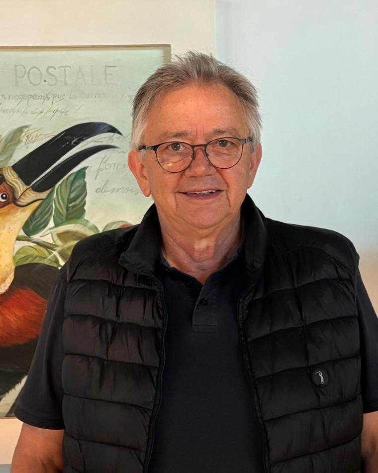 Tarcisio Miguel Sevegnani ao lado de um quadro com um tucano